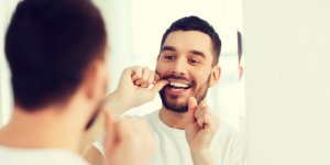 'man flossing in mirror'